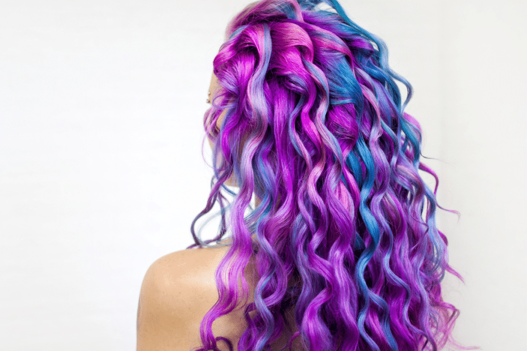 Woman with a mix of hair coloring including pink, purple, and blue.
