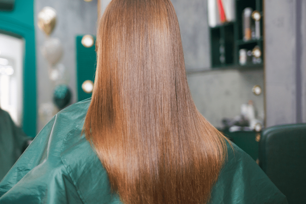 Back of a woman's head with silky smooth reddish colored hair.