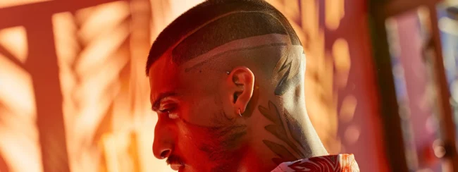 a man with a bold geometric pattern shaved into his undercut hairstyle.