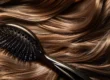 a sleek, elegant hairbrush with long, soft bristles against a backdrop of shiny, flowing long hair.