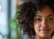 a medium wide shot of a woman with curly hair looking over her shoulder toward the camera