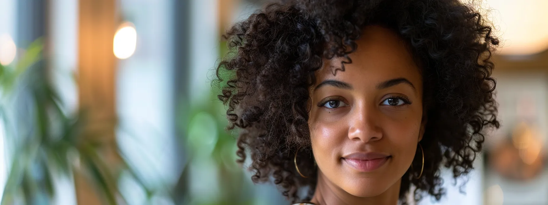 Essential Guide to Maintaining Curly Hair After a Haircut 1 a medium wide shot of a woman with curly hair looking over her shoulder toward the camera